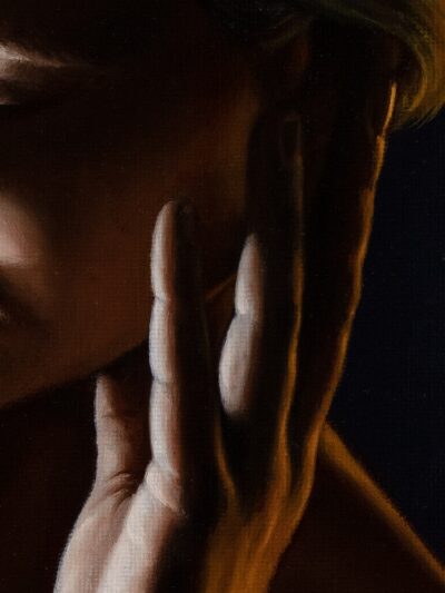 A detail of a painting showing a hand on a face, using chiaroscuro to highlight the skin against dark shadows.