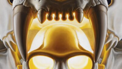 Detailed oil painting by Tomas Trman Rucker, capturing the upper part of the tiger's fangs surrounding a langur skull in a radiant golden glow.